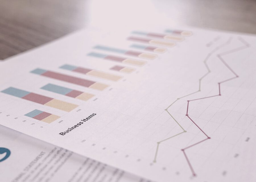 LTV und CAC — Balken- und Liniendiagramme auf Geschäftsdokument, Schreibtischperspektive